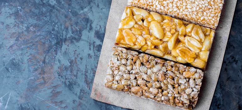 Top view of three bars Nuts in caramel, honey on gray table background