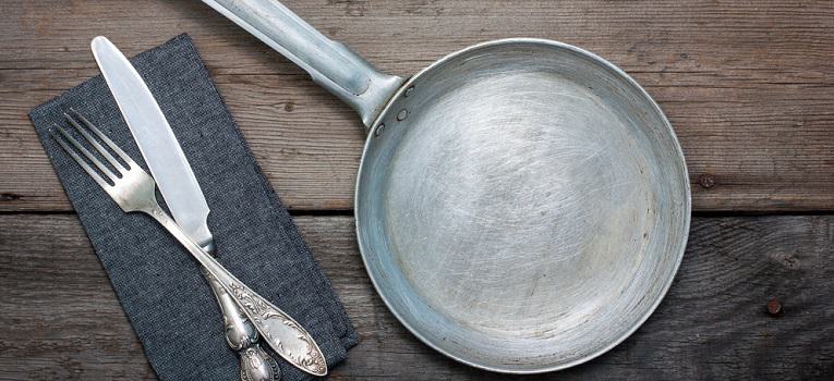 An empty aluminum pan on a wooden table