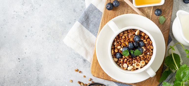Homemade muesli in a white plate on the light gray kitchen table