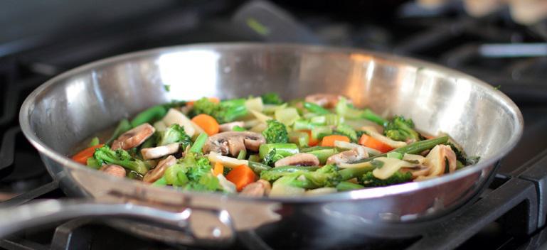 Stir fry vegetables cooking in a stainless steel pan