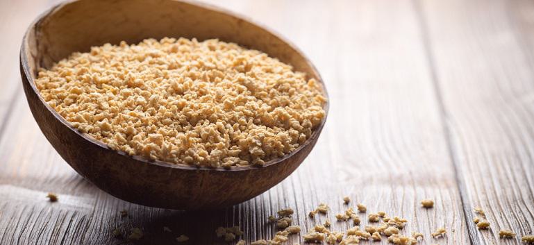 Textured Soy protein i na wooden bowl on a wooden surface, eco product.