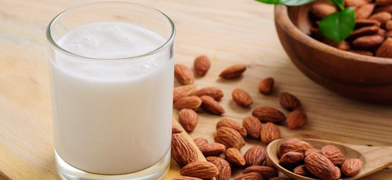 Almond milk with almond on a wooden table