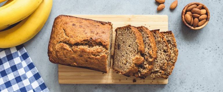 Banana bread with nuts sliced on concrete table background