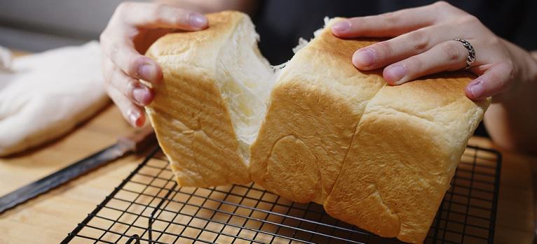 Woman hands breaking Fresh homemade loaf of bread