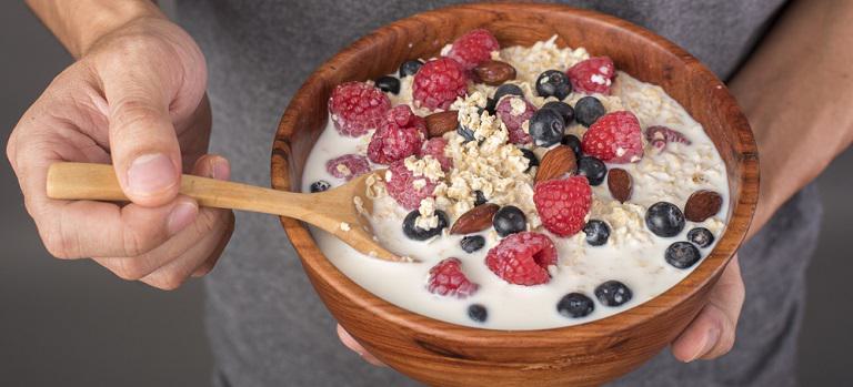 Healthy breakfast ingredients in man hand