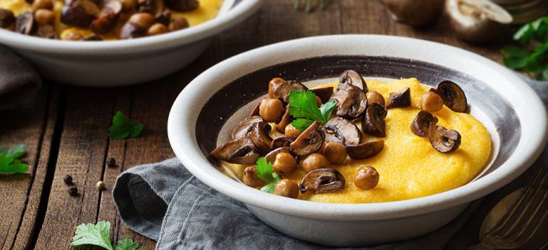Traditional Italian polenta or boiled cornmeal with mushrooms and chickpeas garnished with fresh parsley