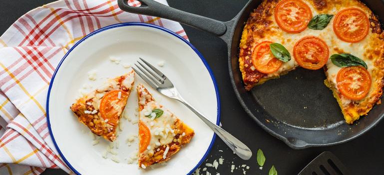 Slice of polenta pizza and skillet pan