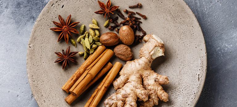 Collection of spices - anise star, cardamon, cinnamon stick, ginger root, nutmeg