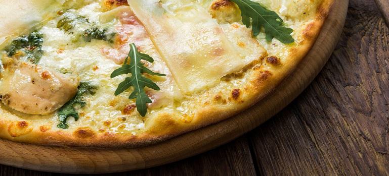 Delicious pizza with chicken, parmesan, tomatoes, white sauce and fresh arugula