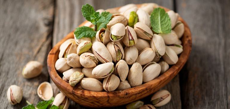 Bowl with pistachios on a wooden table