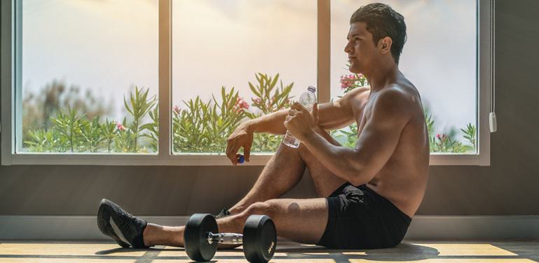man resting after workout with dumbells